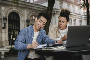 Positive multiethnic students doing homework in team
