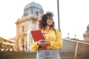 Woman in yellow jacket holding books