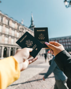 Anonymous tourists showing us passports on street on sunny day